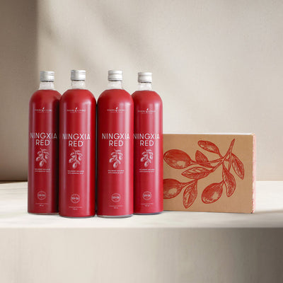 Four NingXia Red bottles surrounded by cartons and single-serve sachets